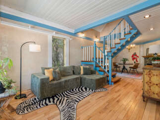 Step into this stylish living space featuring a unique zebra-print rug and a cozy sectional sofa.