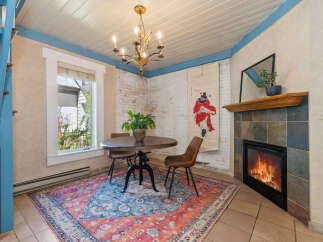 Step into this charming dining area, featuring a cozy fireplace and a unique, artistic touch.