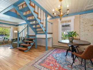 This charming property boasts a unique interior design with a striking blue staircase as a focal point.