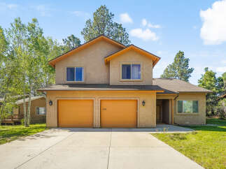 This stunning two-story home boasts a warm and inviting exterior with a charming design.