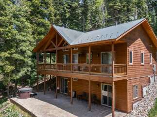 Escape to your dream mountain retreat! This stunning cabin boasts a spacious deck, perfect for enjoying the serene forest views.
