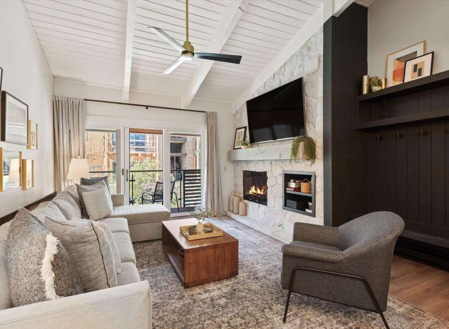 Step into luxury with this stunning property, featuring a cozy living room with a fireplace and a modern design.