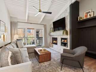 Step into luxury with this stunning property, featuring a cozy living room with a fireplace and a modern design.