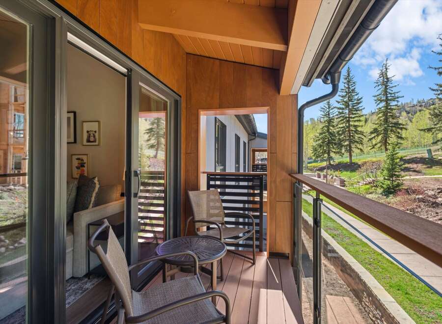 Enjoy breathtaking views from this stunning balcony! This outdoor space features a cozy seating area, perfect for relaxing and taking in the surrounding natural beauty.