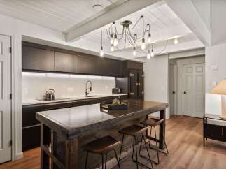This stunning kitchen boasts a modern design with sleek, dark cabinetry and a striking island.