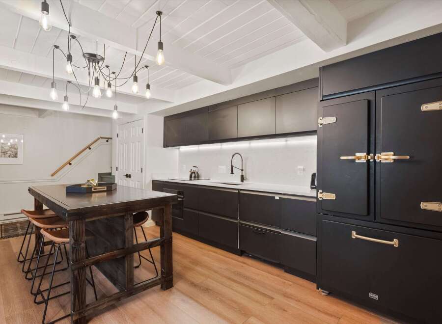 Step into this stunning kitchen, featuring sleek black cabinetry and a striking island.
