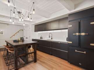 Step into this stunning kitchen, featuring sleek black cabinetry and a striking island.