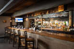 This inviting bar area features a warm, rustic ambiance, perfect for a cozy gathering.