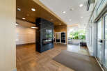 Step into the inviting lobby of this modern property, showcasing a sleek design with a striking black marble pillar and a built-in fireplace.