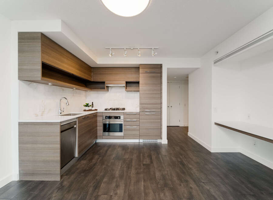 This modern kitchen boasts sleek cabinetry, stainless steel appliances, and a pristine white countertop.
