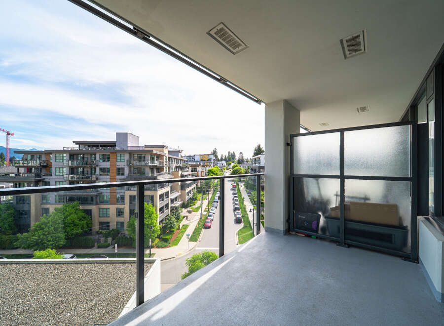 Enjoy stunning views from this modern balcony overlooking a vibrant cityscape.