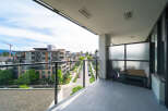 Enjoy stunning views from this modern balcony overlooking a vibrant cityscape.
