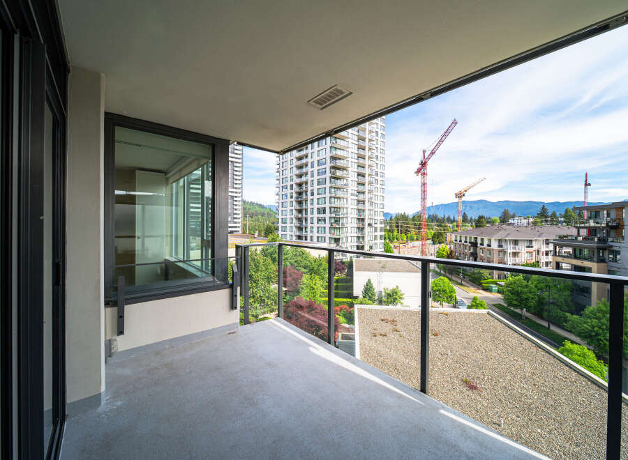 Enjoy stunning views from this modern balcony overlooking a vibrant cityscape.