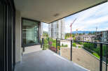 Enjoy stunning views from this modern balcony overlooking a vibrant cityscape.
