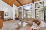 Step into luxury with this stunning property featuring a spacious living area with a unique wood-paneled ceiling and large windows that flood the space with natural light.