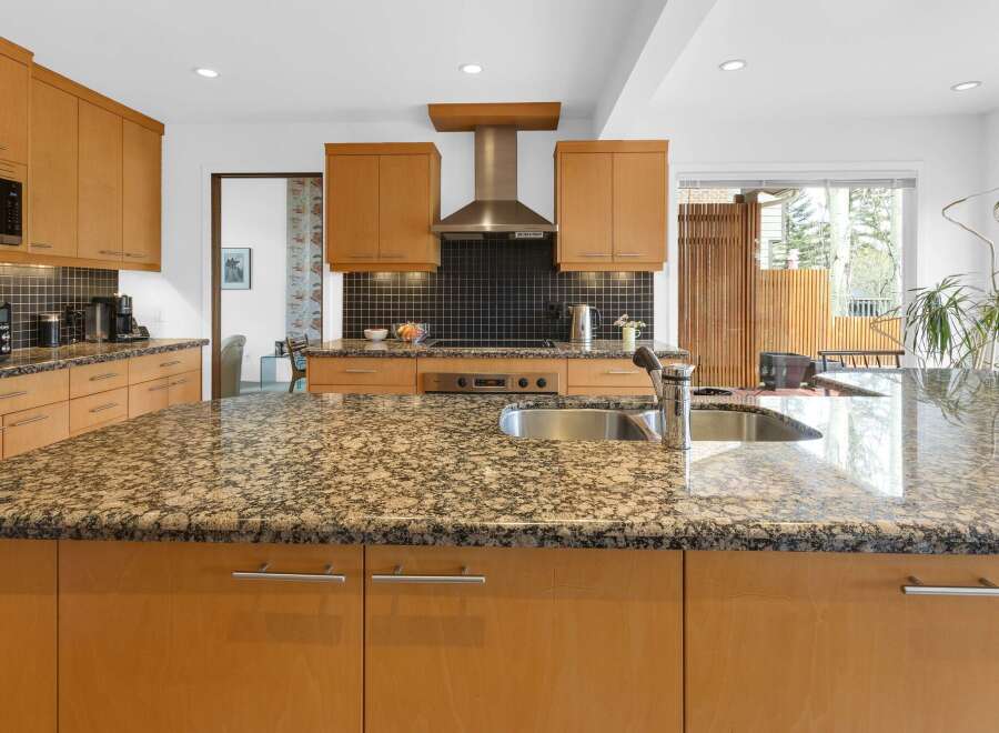 This stunning kitchen boasts a spacious granite countertop island, perfect for meal prep and entertaining.