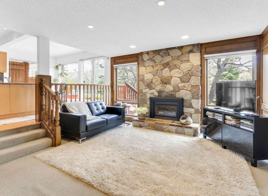 Step into luxury with this stunning living room featuring a cozy fireplace and a plush, oversized rug.