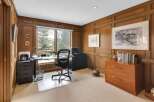 Step into this elegant home office, featuring rich wood paneling and a serene ambiance.