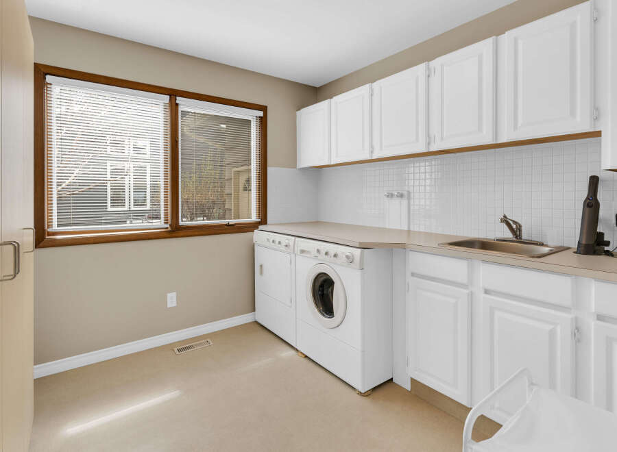 This bright and functional laundry room features ample storage and a convenient layout.