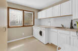This bright and functional laundry room features ample storage and a convenient layout.