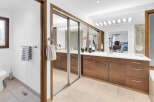 Step into luxury with this stunning bathroom featuring a sleek vanity and ample storage.
