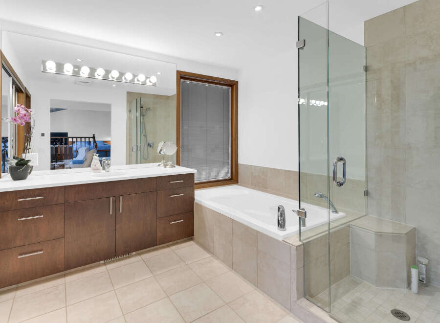 Step into luxury with this stunning bathroom featuring a sleek glass shower enclosure and a relaxing soaking tub.
