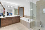 Step into luxury with this stunning bathroom featuring a sleek glass shower enclosure and a relaxing soaking tub.