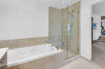 This luxurious bathroom features a modern design with a sleek, white bathtub and a separate glass-enclosed shower.