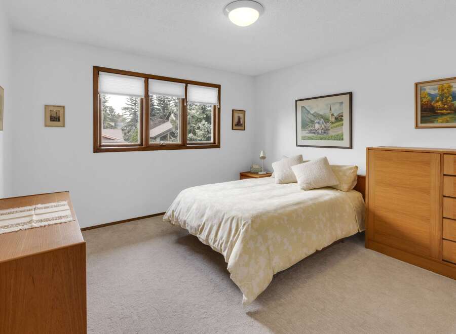This inviting bedroom features a cozy bed with a floral patterned comforter, perfect for a relaxing retreat.