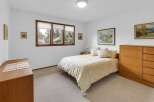 This inviting bedroom features a cozy bed with a floral patterned comforter, perfect for a relaxing retreat.