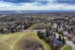 An aerial view showcases a beautiful residential area with lush greenery and stunning mountain views.