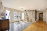 Step into luxury with this stunning entryway, featuring a grand staircase and elegant double doors.