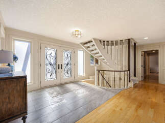 Step into luxury with this stunning entryway, featuring a grand staircase and elegant double doors.