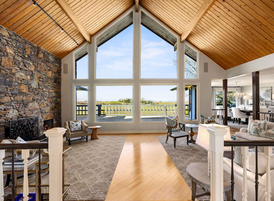 This stunning property boasts a grand living space with soaring ceilings and expansive windows that flood the room with natural light.