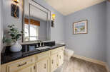 This elegant bathroom features a stylish vanity with a sleek black countertop and cream-colored cabinets, offering ample storage.