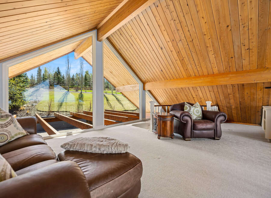 This stunning property boasts a unique architectural design with a vaulted, wood-paneled ceiling that adds warmth and character.