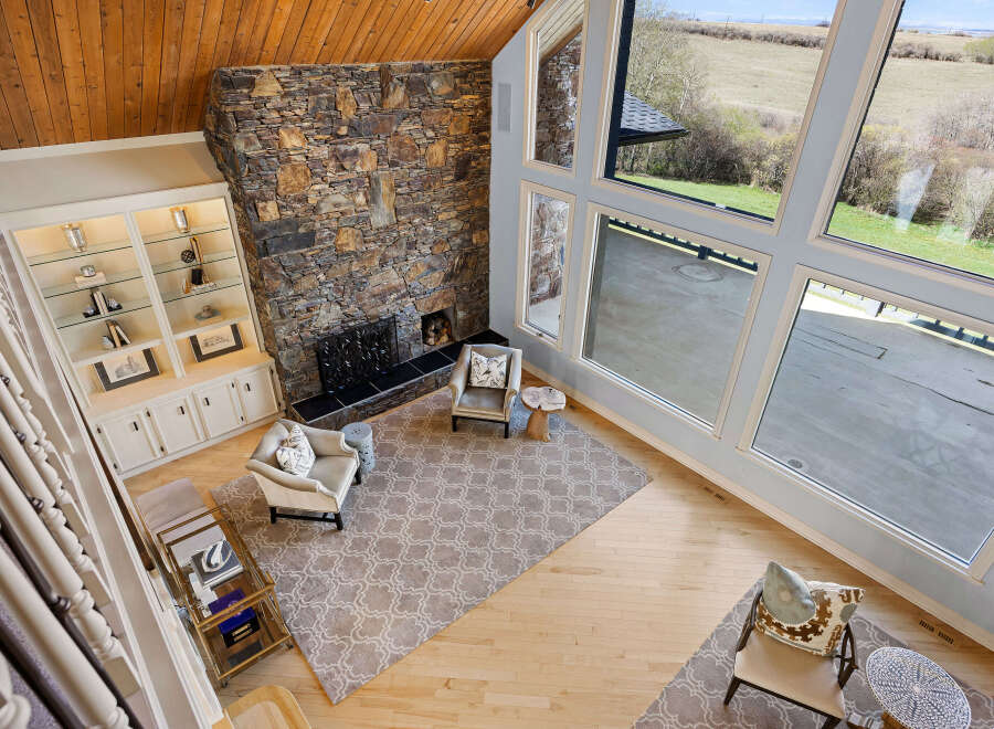 This stunning property boasts a grand living space with a striking stone fireplace, creating a warm and inviting atmosphere.