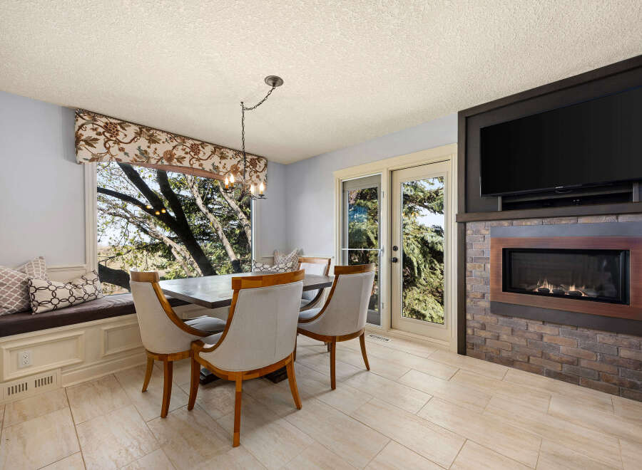 This stunning dining room features a cozy window seat, perfect for enjoying the natural light and scenic views.