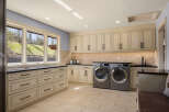 This stunning laundry room boasts a sleek design with ample storage and modern appliances.