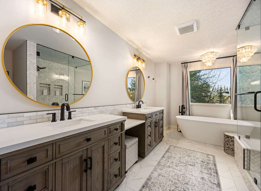 Step into luxury with this stunning bathroom! Featuring a sleek design, this space boasts a double vanity with ample storage and a beautiful round mirror.