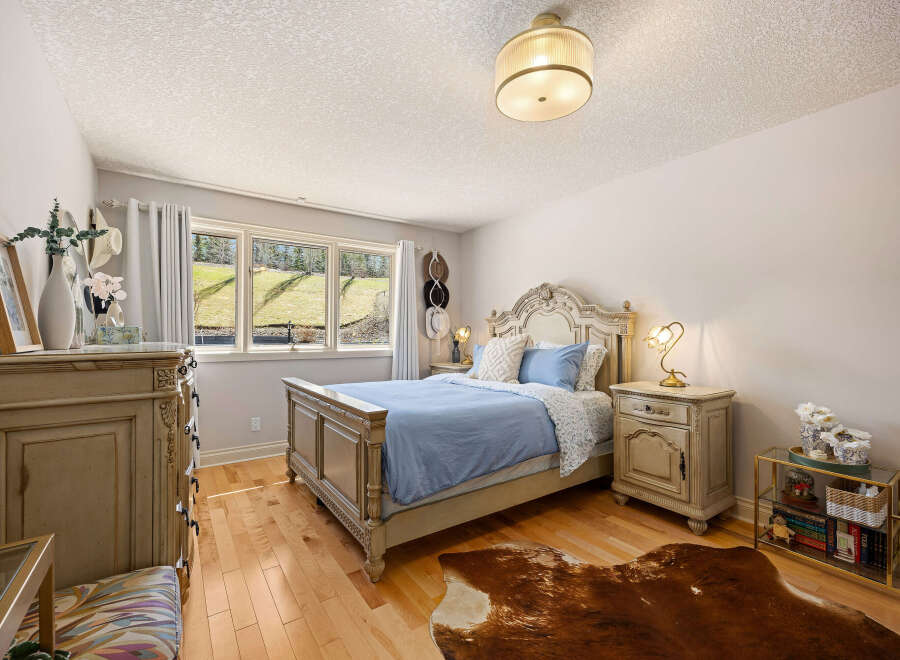 This elegant bedroom features a beautifully crafted bed with a detailed headboard, creating a focal point of luxury.