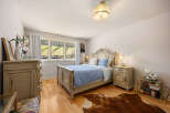 This elegant bedroom features a beautifully crafted bed with a detailed headboard, creating a focal point of luxury.