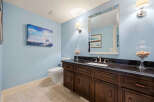 This stunning bathroom features a beautiful vanity with dark wood cabinets and a sleek black countertop.