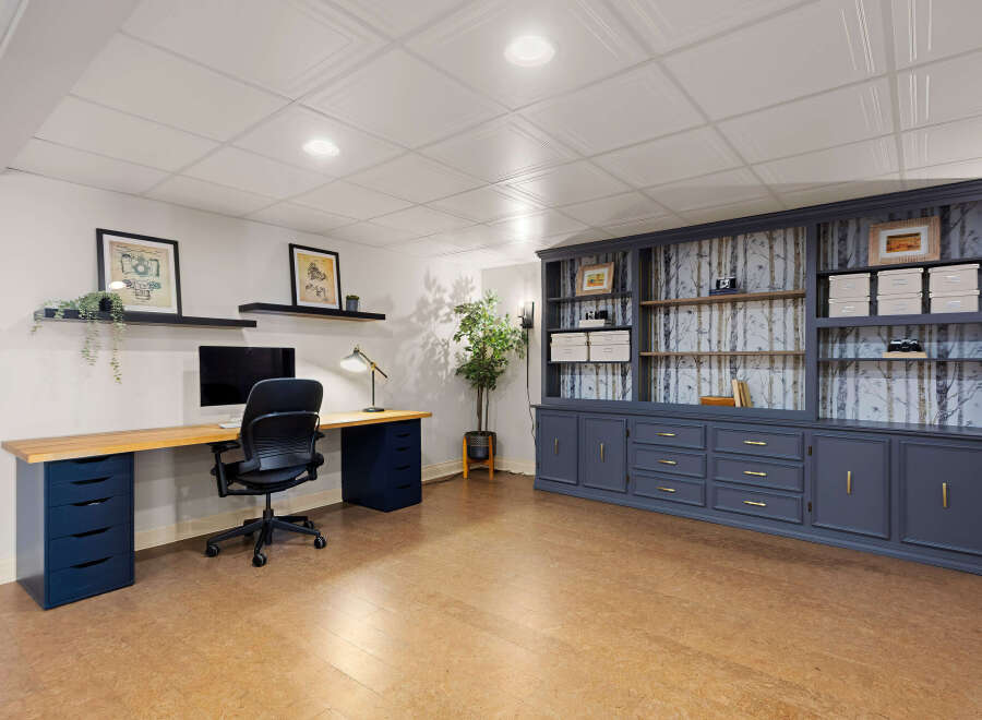 This stunning home office features a custom-built desk and a large built-in bookcase, providing ample storage and workspace.