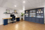 This stunning home office features a custom-built desk and a large built-in bookcase, providing ample storage and workspace.