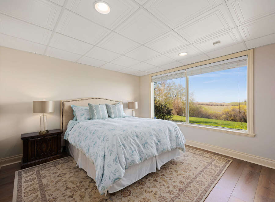 Step into a serene bedroom retreat, bathed in natural light from expansive windows.