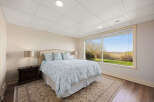 Step into a serene bedroom retreat, bathed in natural light from expansive windows.