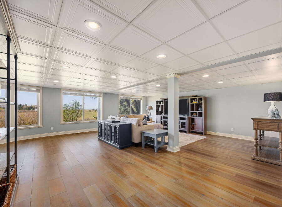 This stunning property boasts a spacious living area with beautiful hardwood floors and a stylish coffered ceiling.