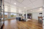 This stunning property boasts a spacious living area with beautiful hardwood floors and a stylish coffered ceiling.