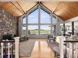 Experience luxury living in this stunning property, featuring a grand living room with soaring ceilings and expansive windows that frame breathtaking views.